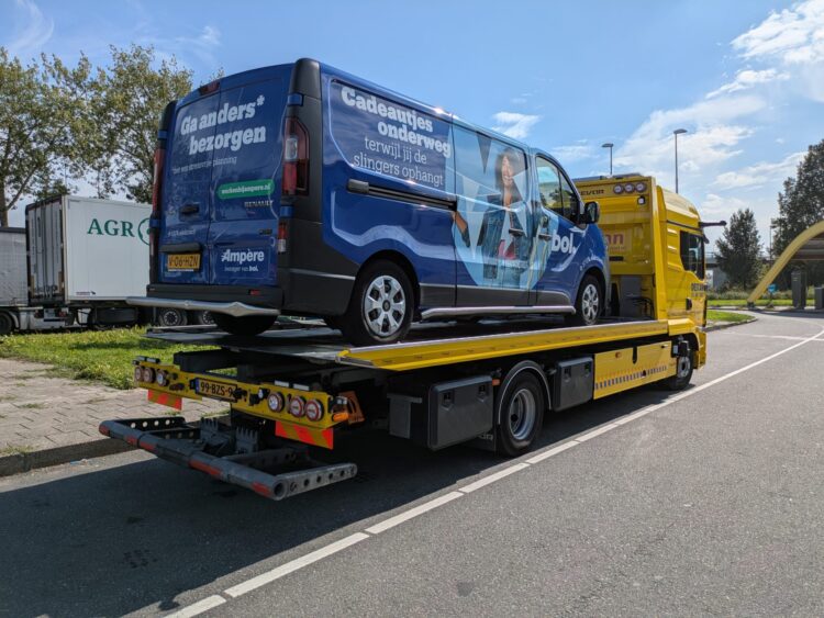 Een werkbus wordt weggehaald op een takelwagen