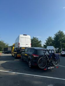 De takeldienst sleept een vakantieganger weg van de weg die een ongeluk heeft gehad