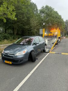 Deze auto heeft een lekke band en wordt opgetakeld door de sleepdienst van Destan